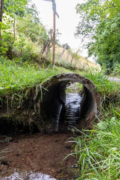 The stream runs through the pipe The stream runs through a concrete pipe opening bridge stock pictures, royalty-free photos & images