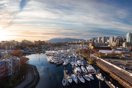 View of Vancouver City in False Creek, BC, Canada. Sunny Cloudy Day. Modern Cityscape, Granville Island, residential homes, marina and buildings. Sunset Sky Art Render