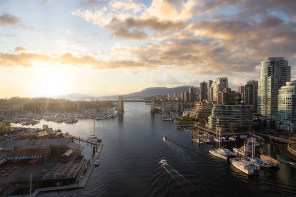 Aerial View of Granville Island in False Creek with modern city skyline and mountains in background. Aerial View of Granville Island in False Creek with modern city skyline and mountains in background. Downtown Vancouver, British Columbia, Canada. Sunset Sky Art Render granville island stock pictures, royalty-free photos & images