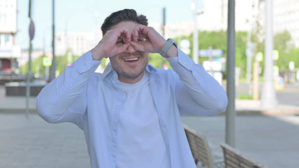 istock Happy Man Searching with Handmade Binocular Outdoor 1424104543