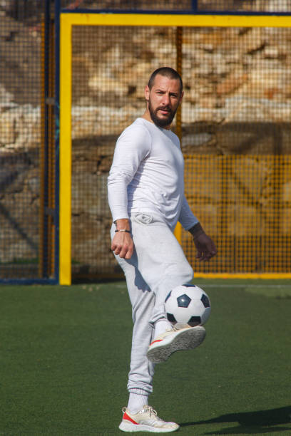 istock Male soccer player juggles a ball on a soccer field 1424105607