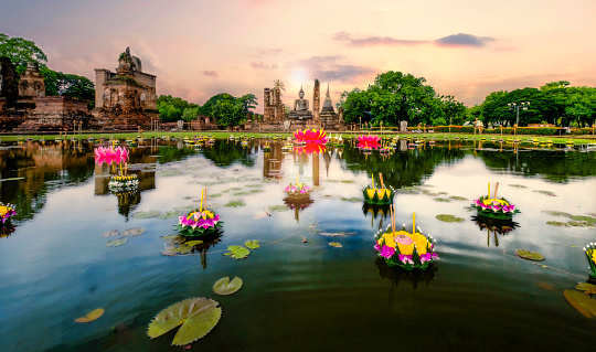 Sunset over Wat Mahathat with reflection on pond with man-made lotus in multiple color.