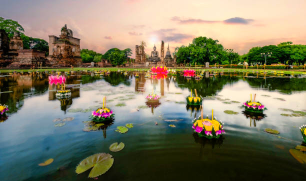 Sunset over Wat Mahathat with reflection. Sunset over Wat Mahathat with reflection on pond with man-made lotus in multiple color. loi krathong stock pictures, royalty-free photos & images