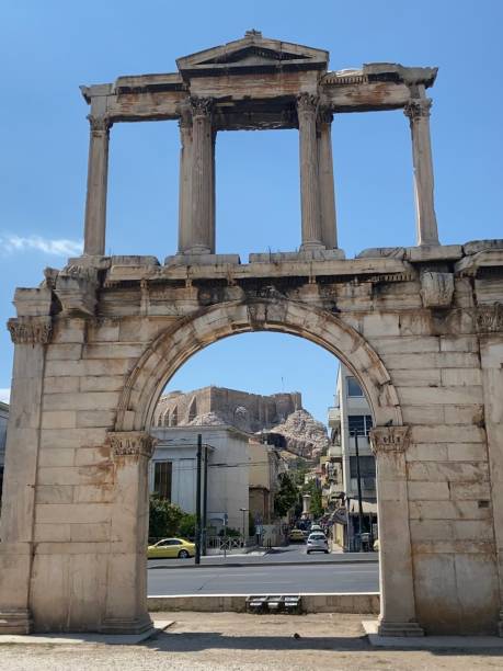 guardando attraverso l'arco di adriano verso l'acropoli di atene in una limpida giornata estiva - clear sky acropolis athens greece greece foto e immagini stock