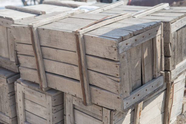 A stack of wooden crates with a label that says Fragile on the top. The crates are stacked on top of each other and are leaning against a fence