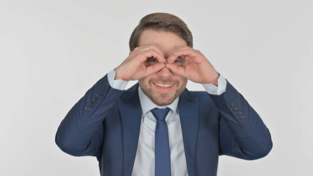 istock Young Businessman Searching with Handmade Binocular on White Screen 1424126162