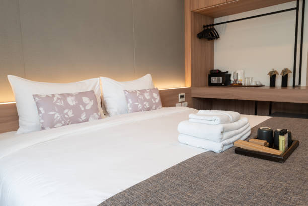 istock Side view of hotel amenities (such as towels, shampoo, soap, toothbrush etc) on the bed. 1424131583