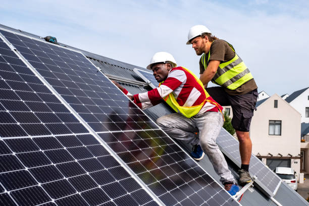 Workers installing rooftop solar panels stock photo