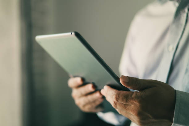 istock Entrepreneur checking daily work plan and email in tablet, business man checking stock investment, man standing in house looking at tablet in the morning. 1424140076