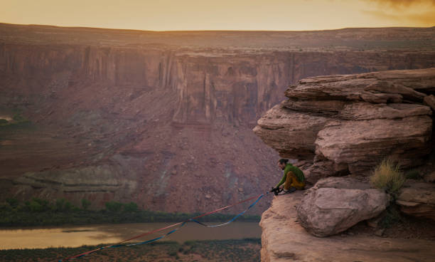 istock Young man setting the ropes in Moab park for high lining 1424142699