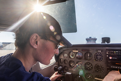 Captain of Cessna Caravan 1000 airplane adjusts controls during flight to San Pedro, Belize.