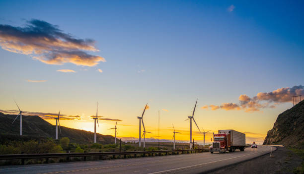 Semi truck speeding in front of Wind turbines in Utah stock photo