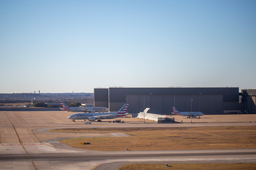 Aerial view of a  group of American Airlines airplanes parked at hangar at Dallas/Fort Worth International Airport in January 2022
