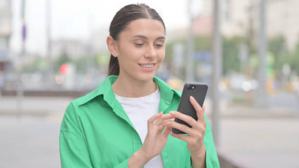 istock Hispanic Woman Browsing Internet on Smartphone Outdoor 1424149809