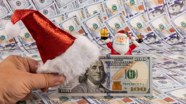 istock 100 american dollar bills and christmas hat 1424152577
