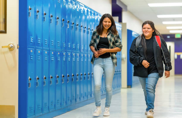 istock Friends walking thru school corridor 1424154751
