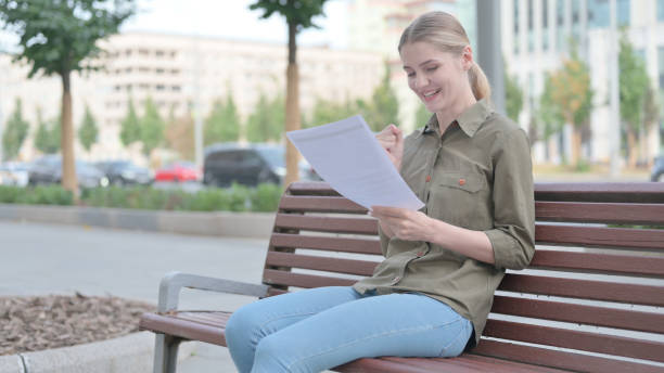 istock Woman Enjoying Success while Reading Documents Outdoor 1424160084