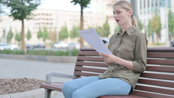 istock Woman Reacting to Loss while Reading Documents Outdoor 1424160125