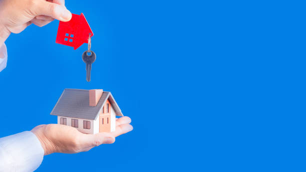 istock Hand with a little house and keys. 1424161224