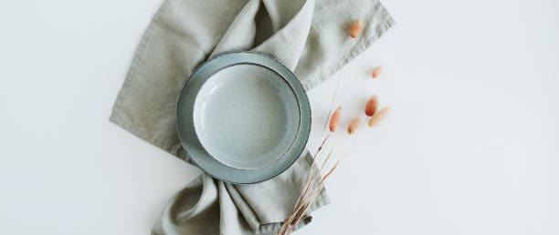 istock Plate mockup,linen napkin, dry grass top view empty modern minimal table place setting neutral green colors banner. Space for text or menu .Business food brand template. Scandinavian style tableware. 1424162307