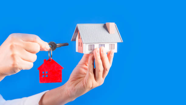 istock Hand with a little house and keys. 1424162340