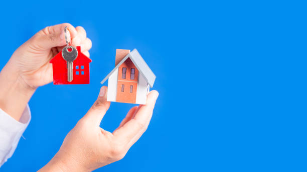 istock Hand with a little house and keys. 1424162532