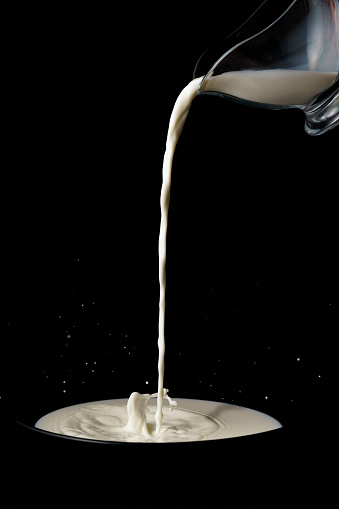 Milk splash in a light bulb, levitating metaphor isolated on black