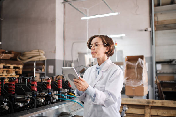 istock Female executive working with tablet, checking factory machines 1424164448