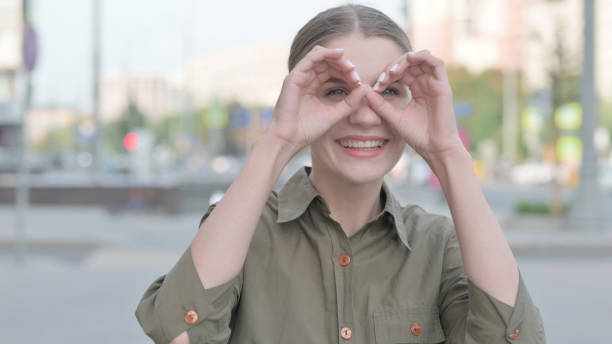 istock Woman Looking Around with Handmade Binocular Outdoor 1424170806