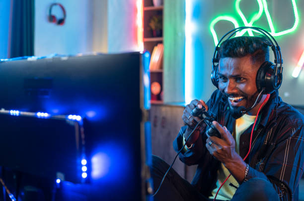 istock Happy gamer with headphones celebrating win while playing video game at home on computer - concept of tournament, happiness and achievement 1424180248