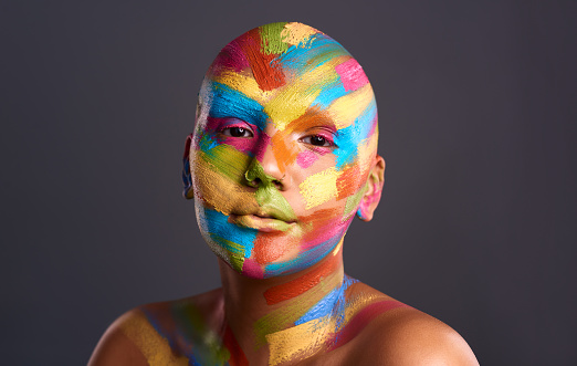 Creative, artist and paint face woman portrait in a studio with dark contrast background mockup or copy space. Creativity, aesthetics and colorful bright makeup for skin, beauty and cosmetics mock up