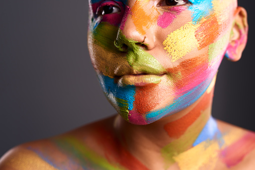 Creative expression, body paint and a woman with colorful face painting. Beauty, feminism and female empowerment in abstract art and cosmetics. Freedom, skin and girl power with fantasy facial makeup