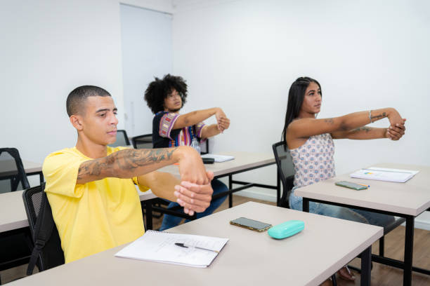 istock Young people in the classroom performing stretching 1424180639