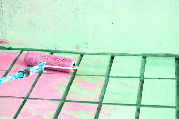istock Roller painting green wall surface with pink paint 1424183190