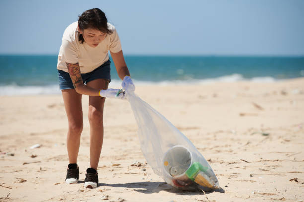 istock Woman Collecting Trash on Beach 1424186206