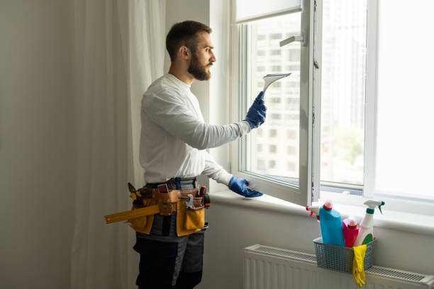 Young man washing window in office. stock photo