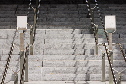 Gray concrete staircase with two blank signs.