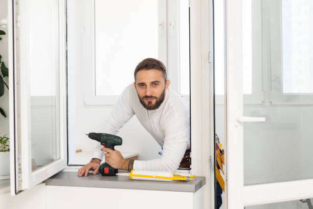 istock handsome young man installing bay window in a new house construction site. 1424187559