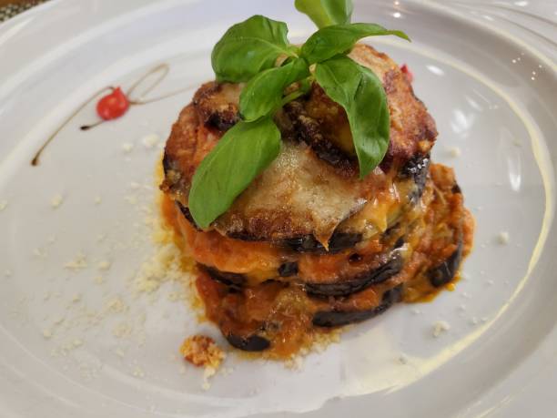 Aubergine Parmigiana tower with herb oil stock photo