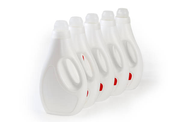 plastikflaschen mit flüssigem waschmittel auf weißem grund - laundry detergent cleaning product concepts measuring cup stock-fotos und bilder