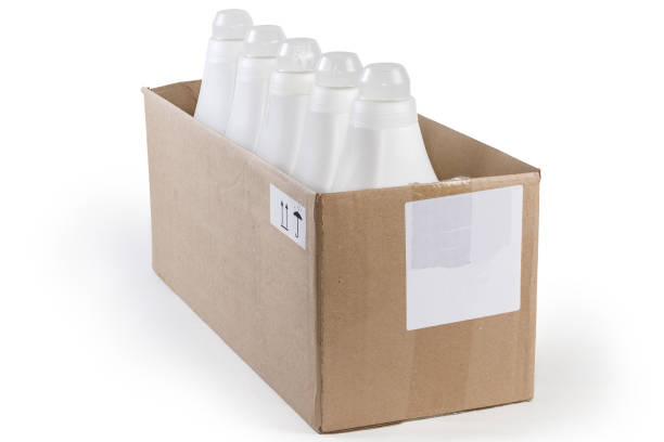 plastikflaschen mit flüssigem waschmittel im karton - laundry detergent cleaning product concepts measuring cup stock-fotos und bilder