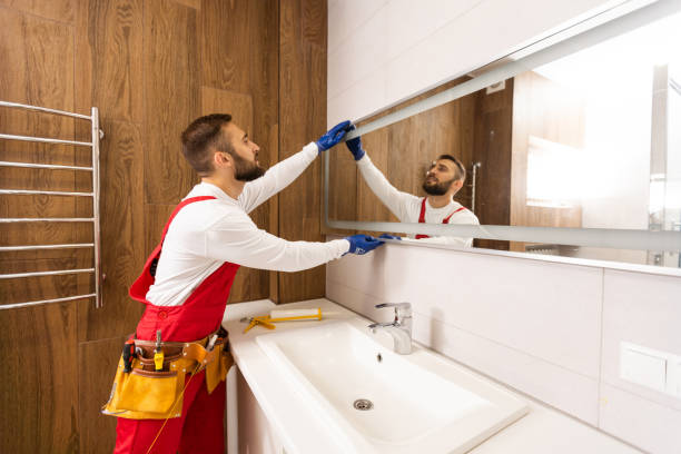 istock Man installing a mirror on wall in his renewed bathroom 1424192275