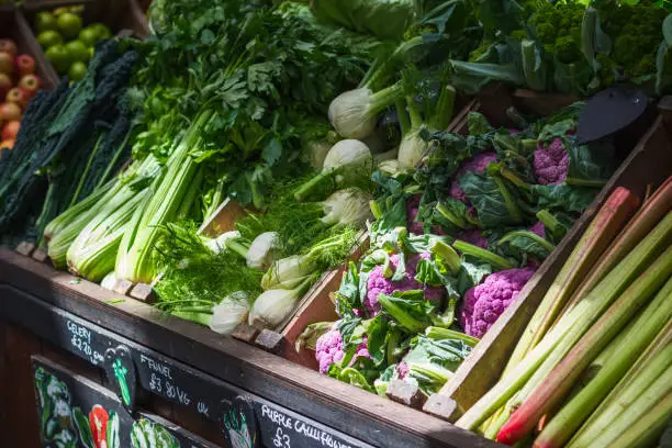 A variety of vegetables displayed in wooden crates at a produce stall in Borough Market in London, England