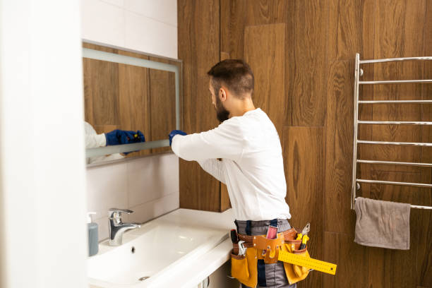 istock Man installing a mirror on wall in his renewed bathroom 1424194852