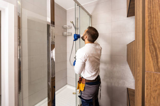 Plumber installing a shower cabin in bathroom stock photo