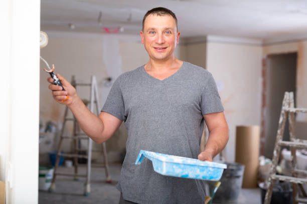 istock Man painting wall in apartment 1424195355