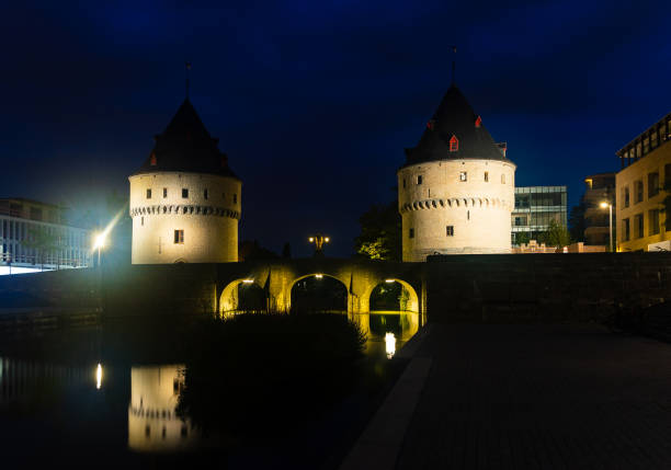 Illuminated night view of Broel Towers along the river Lys in Kortrijk, Belgium