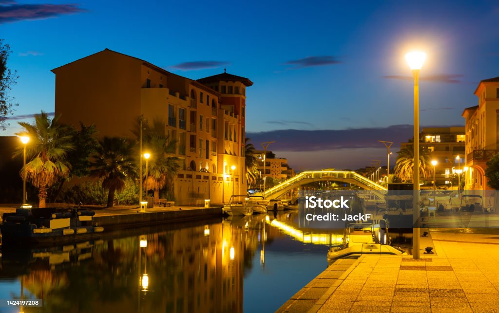 French town of Frejus overlooking embankment and marina at dusk Scenic view of French town of Frejus on Mediterranean coast overlooking residential houses on embankment and marina with moored luxury yachts at dusk in early autumn Fréjus - France Stock Photo