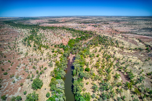 Kalkaringi, Northern Territory, Australia - August 26, 2022: Aerial view of the Victoria River near the township of Kalkaringi.\n\nKalkarindji is a community on the land formerly held under the Wave Hill Cattle Station. In 1966, the Aboriginal station workers, led by Vincent Lingiari, staged the Gurindji strike, also known as the Wave Hill Walk Off, in protest against oppressive labour practices and land dispossession. In their honour, we gather on Gurindji Country every August to commemorate and celebrate at the Gurindji Freedom Day Festival. \n\nFlowing for 560 kilometres (350 mi) from its source, south of the Judbarra / Gregory National Park, until it enters Joseph Bonaparte Gulf in the Timor Sea, the Victoria River is the longest singularly named permanent river in the Northern Territory.
