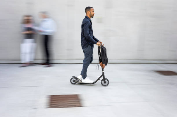 istock Businessman commuting to work with a push scooter 1424200888
